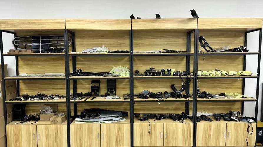 Shelves displaying air vents, speaker covers and other interior-component samples at CKCP
